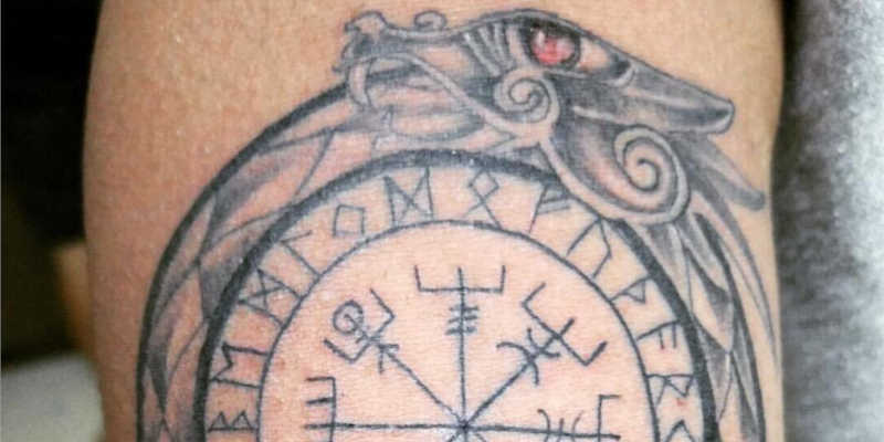 Detalle de tatuaje de Vegvísir rodeado por ouroboros